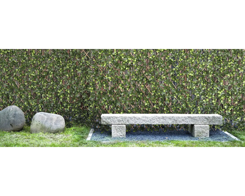 Szene mit künstlicher Hecke, Steinbank und zwei Steinen im Garten