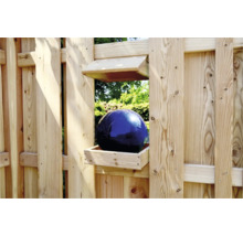Boule décorative en verre bleu dans une caisse en bois sur une clôture de jardin
