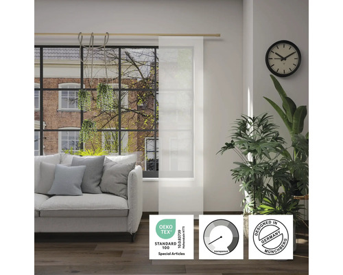 Wohnzimmer mit Sofa und transparentem Flächenvorhang mit Öko-Tex Standard 100 Siegel, Transparenz-Symbol und Designed in Germany Siegel.