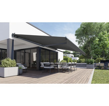Terrasse avec store, table et chaises devant une maison