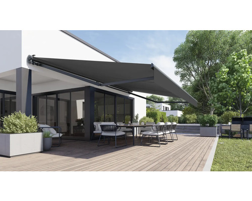 Terrasse avec store, table et chaises devant une maison