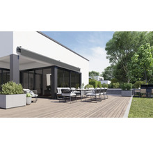Terrasse avec store, table à manger et chaises devant une maison d''habitation
