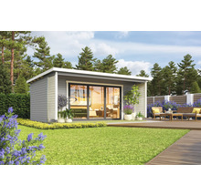 Maison de jardin moderne avec terrasse et coin salon dans un écrin de verdure.