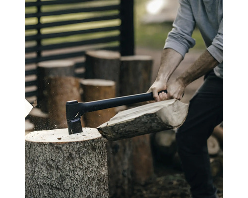 Une personne fend du bois avec une hache.