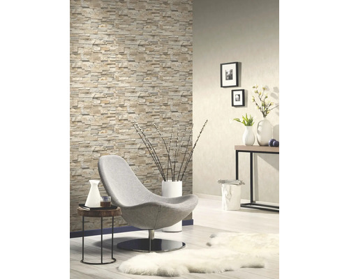 Wohnzimmer mit Steinoptik Tapete, Sessel und Dekorationen für ein gemütliches Ambiente