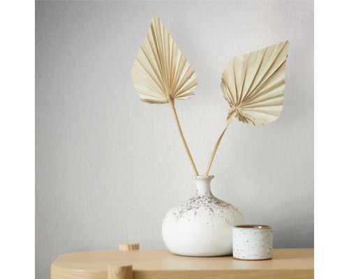 Dekorative getrocknete Palmenblätter in einer weißen Vase auf einem Tisch