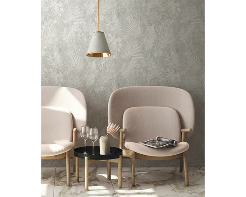 Wohnzimmer mit Tapete mit Blattmuster, zwei Sesseln, Beistelltisch und Hängelampe
