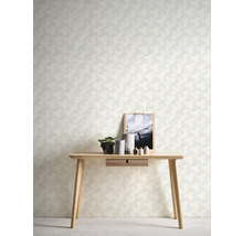 Nahaufnahme einer Wand mit geometrischer Tapete, einem Holztisch, Dekoartikeln und einem Bilderrahmen.