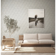 Wohnzimmer mit Sofa, Sessel, Zimmerpflanze, Teppich und gerahmtem Bild an der Wand