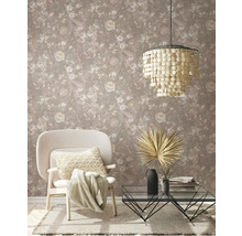 Salon avec papier peint floral, fauteuil, table basse et suspension