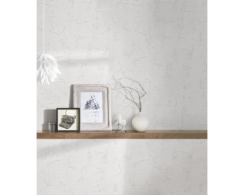 Pièce lumineuse avec papier peint structuré blanc, décorée d''étagères, de photos et d''une lampe.