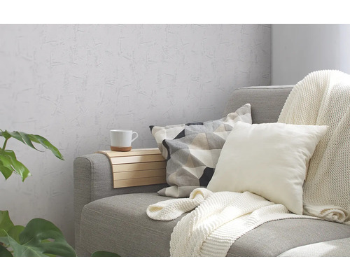 Canapé gris avec coussins, couverture et table d''appoint dans le salon