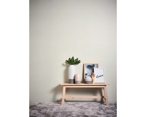 Dekorative Szene mit Bank, Vasen und Bildern an der Wand.