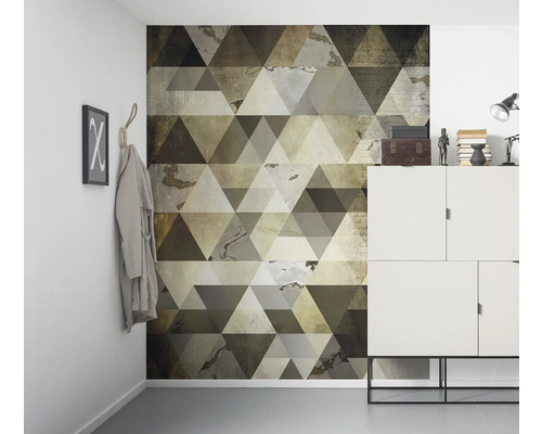 Scène d''intérieur avec un papier peint mural à motif géométrique triangulaire, une armoire blanche et des éléments décoratifs.