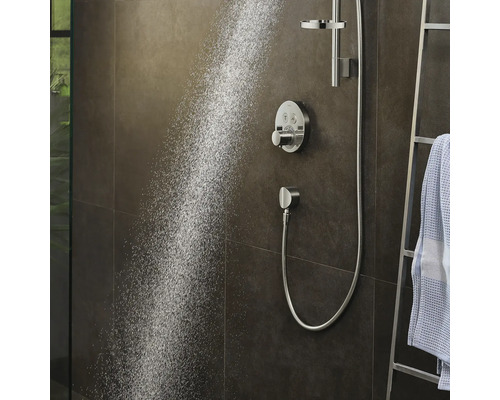 Dusche mit Handbrause und Thermostatarmatur vor dunkler Wand