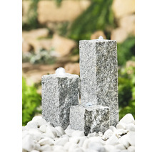Dreiteiliger Gartenbrunnen aus Granit auf weißen Steinen