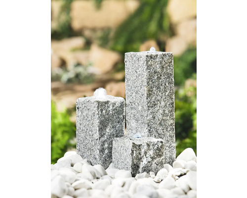 Fontaine de jardin en granit en trois parties sur des pierres blanches