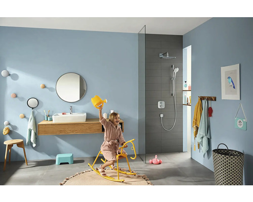 Salle de bains avec douche, lavabo, miroir, tabouret, étagère et enfant sur un cheval à bascule