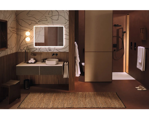 Badezimmer mit Waschtisch, Spiegel mit Beleuchtung und begehbarer Dusche.