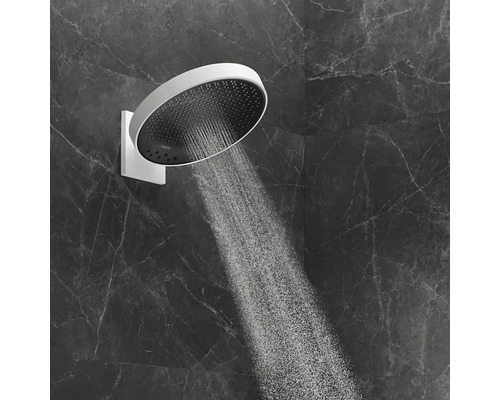 Runde Kopfbrause mit Wasserstrahl an einer Marmorwand