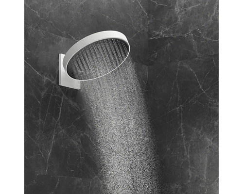 Runde Kopfbrause mit Wasserstrahl an einer dunklen Wand