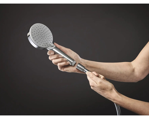 Une main tient une pomme de douche avec raccord de tuyau.