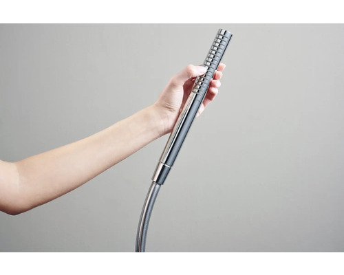 Eine Hand hält einen Duschkopf mit Schlauch.