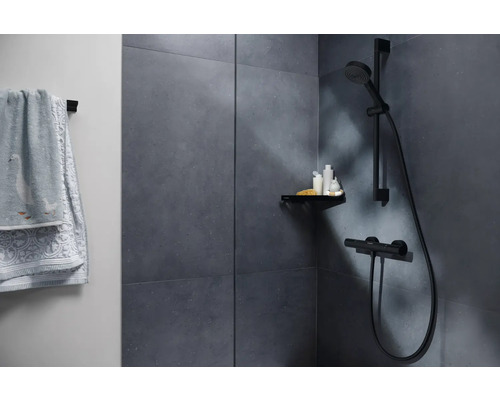 Espace douche avec serviettes, étagère et robinetterie de douche