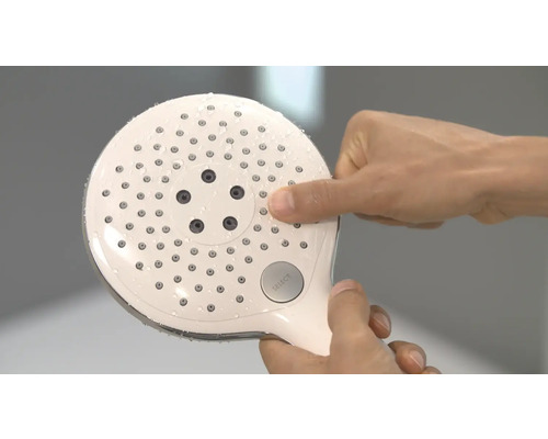 Handbrause mit Wasser und Hand, die einen Knopf drückt