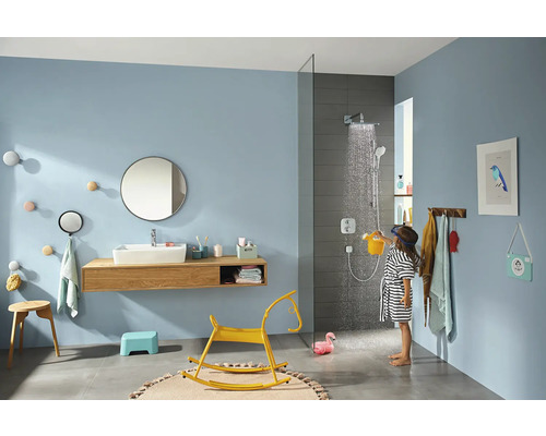 Salle de bain lumineuse avec douche, lavabo, miroir et enfant jouant