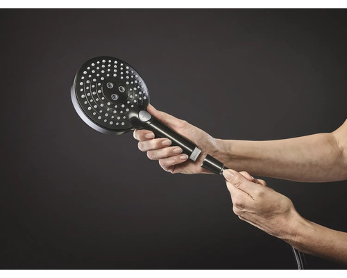 Handbrause mit Schlauch, die von Händen gehalten wird