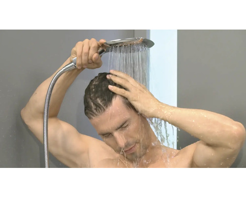 Ein Mann wäscht sich unter einer Handbrause den Kopf.