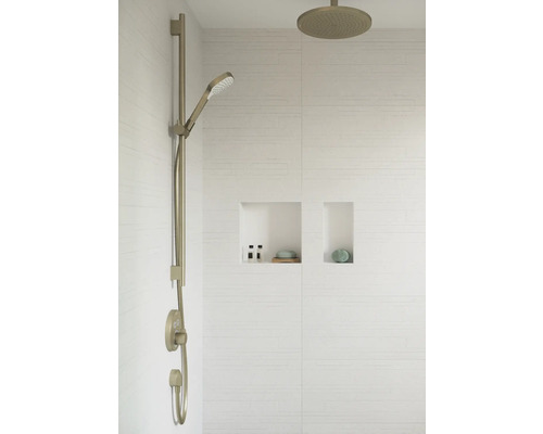 Robinet de douche avec douchette à main et pomme de douche devant un mur carrelé blanc avec deux niches