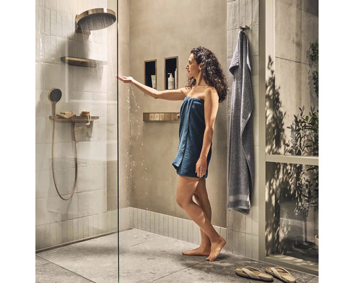 Modernes Badezimmer mit Dusche, Regendusche und Handbrause, sowie einer Frau mit Handtuch