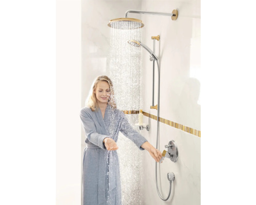 Frau unter laufender Dusche mit Kopf- und Handbrause im Badezimmer