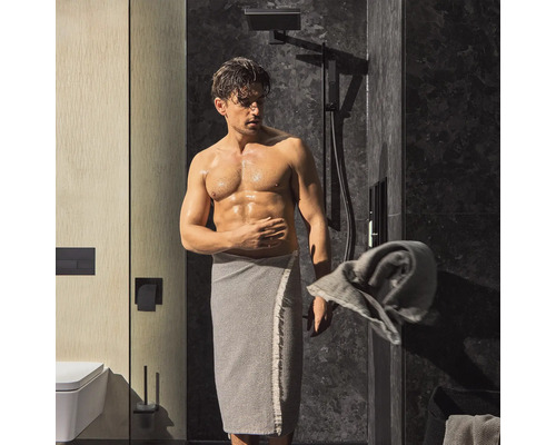 Modernes Badezimmer mit Dusche, Toilette und Mann mit Handtuch