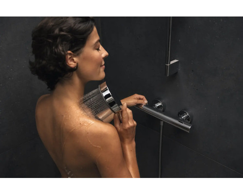 Frau benutzt Handbrause in der Dusche
