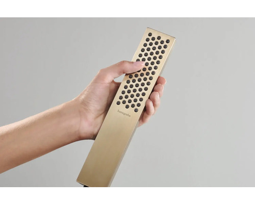 Eine Hand hält eine goldfarbene Handbrause von Hansgrohe.