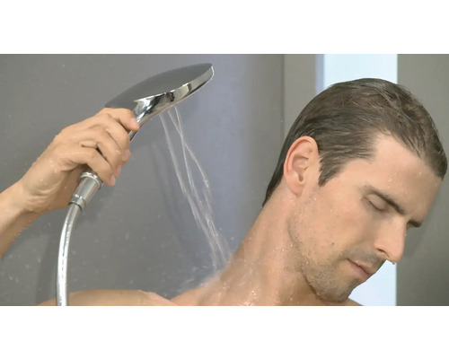 Un homme utilise une douchette à main sous la douche