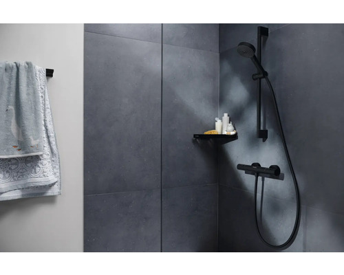 Salle de bains avec douche, serviettes et espace de rangement