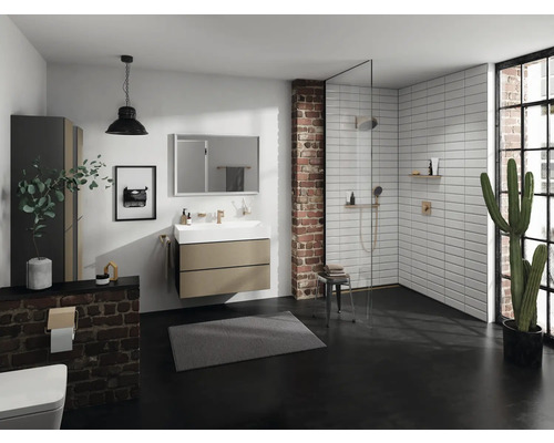 Helles Badezimmer mit Dusche, Waschbeckenunterschrank, Spiegel und Pflanze für eine freundliche Atmosphäre.