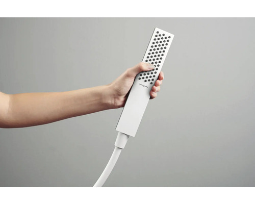 Hand hält eine Hansgrohe Handbrause mit Brauseschlauch.