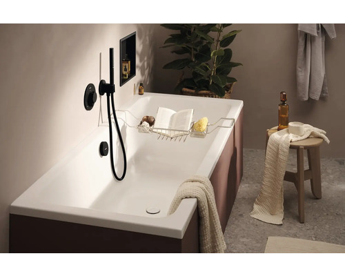 Salle de bains avec baignoire, robinetterie de baignoire, tablette de baignoire et décorations pour une atmosphère relaxante