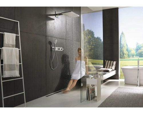 Salle de bain moderne avec douche, porte-serviettes et baignoire devant la fenêtre