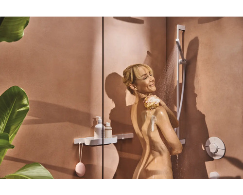 Frau unter der Dusche mit Duschkopf und Duschregal