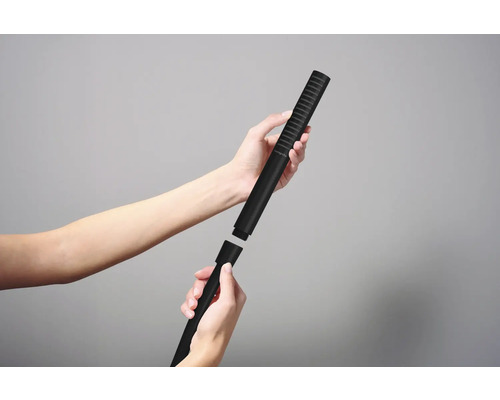 Des mains montent une douchette sur une barre de douche