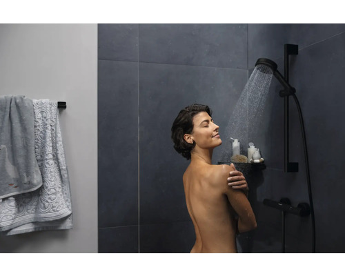 Femme sous un ensemble de douche dans la salle de bain