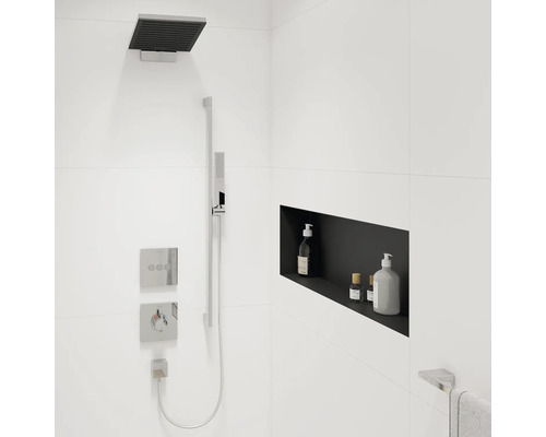 Moderne Dusche mit Kopfbrause, Handbrause, Armaturen und Ablagefach für Pflegeprodukte in einem Badezimmer mit weißen Fliesen.