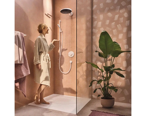 Badezimmer mit Dusche, Duscharmatur, Duschwanne, Handtüchern und Zimmerpflanze für eine entspannende Atmosphäre.