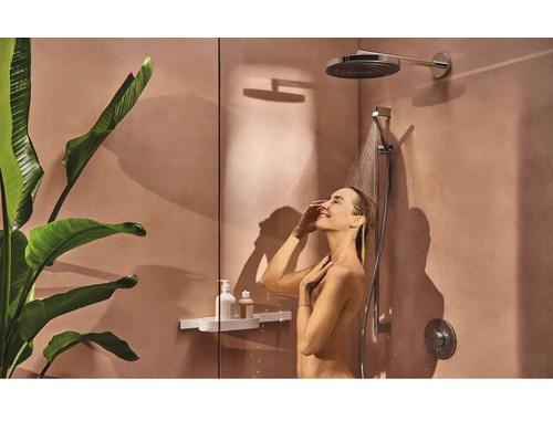 Frau unter der Dusche mit Kopf- und Handbrause in modernem Badezimmer